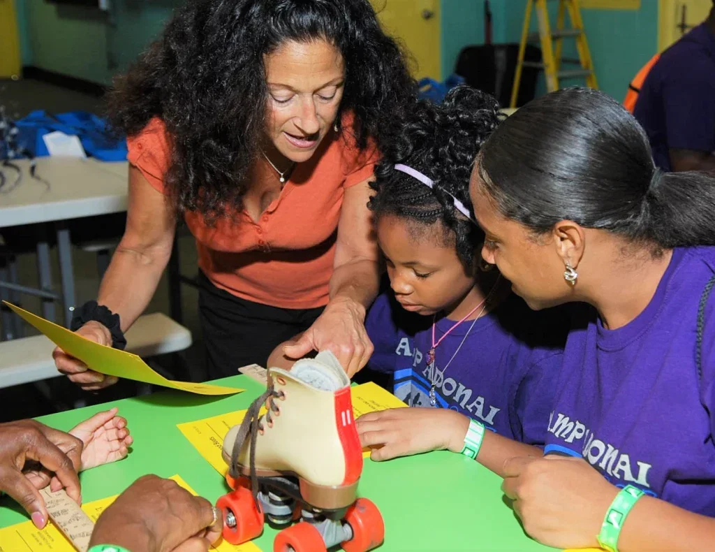 Teacher going over a STEM lesson with a mother and daughter on roller skates