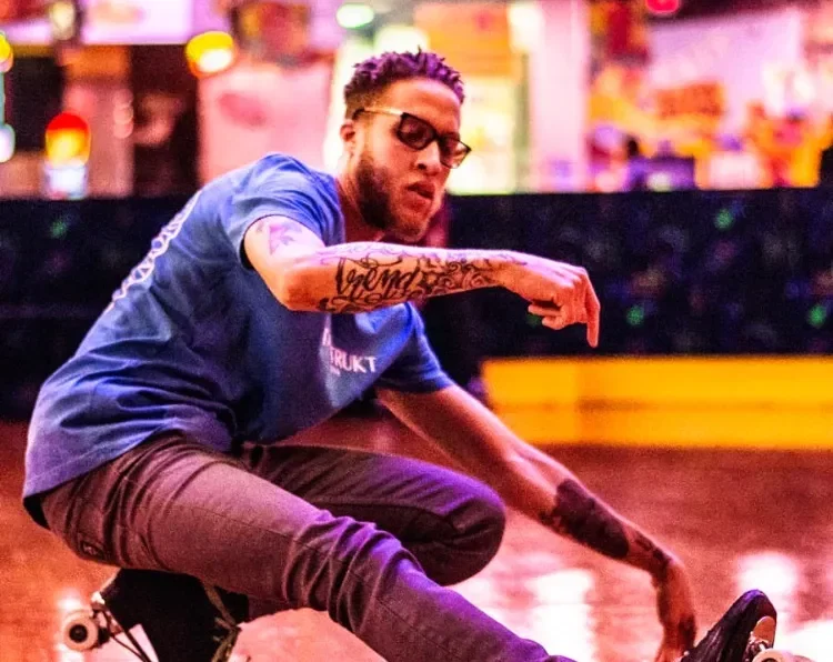 adult male performing a skating move on the ground kicking one leg out